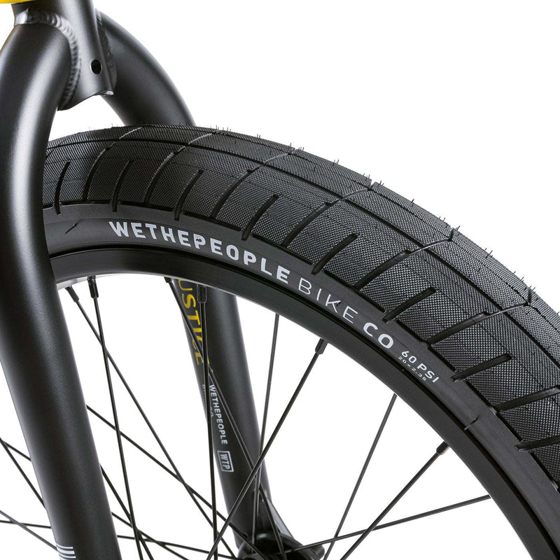 Close-up of Wethepeople Justice Bike front tire and fork with detailed branding on black urban BMX bike wheel and frame