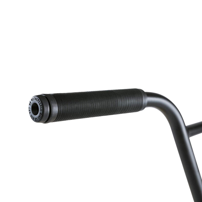 Close-up of black handlebar grip on Wethepeople Justice BMX bike with textured surface and logo end cap