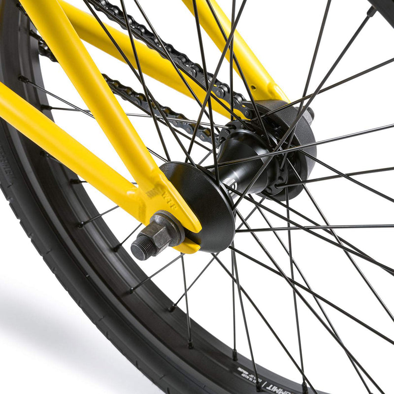Close-up of the rear wheel and yellow frame of the Wethepeople Justice Bike showing spokes, hub, and axle details