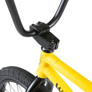 Close-up of the Wethepeople Justice Complete Bike's yellow frame, black handlebars, and front tire.