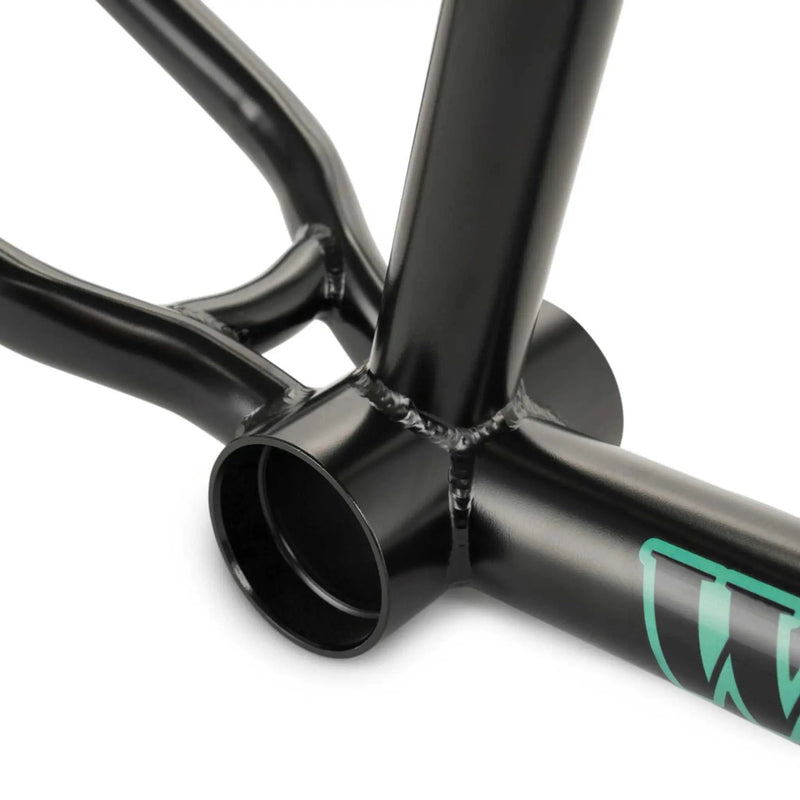 Close-up of black WETHEPEOPLE TRIGGER FRAME BMX bike bottom bracket and tube welds.