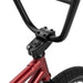 Close-up of the black handlebars and red frame front section of the WETHEPEOPLE JUSTICE BIKE with tire visible