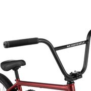 WETHEPEOPLE Justice complete BMX bike with 4130 chromoly frame, black handlebars, and padded seat in matte red finish