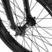 Close-up of the front wheel and fork of the WETHEPEOPLE JUSTICE BIKE showing black spokes, hub, and tire details.