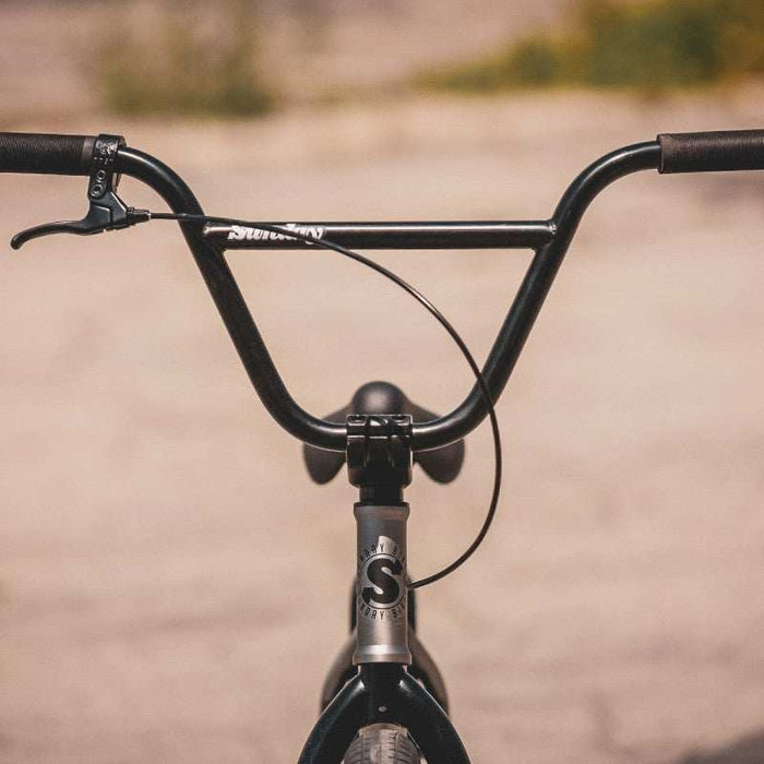 Close-up of Sunday Scout 20" BMX bike handlebars and front brake lever in matte black finish.