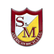 S&M Shield enamel pin with red, white, and yellow colors, made by American Bicycle Co.