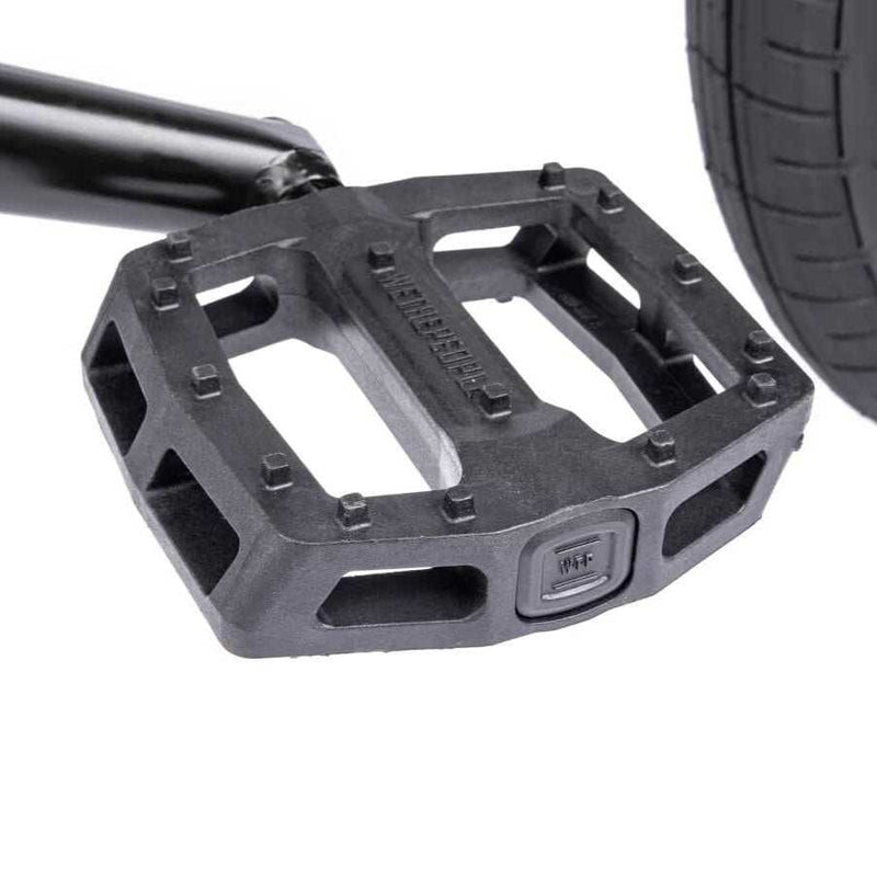 Close-up of Wethepeople Justice Bike black nylon fiberglass logic pedal near rear tire