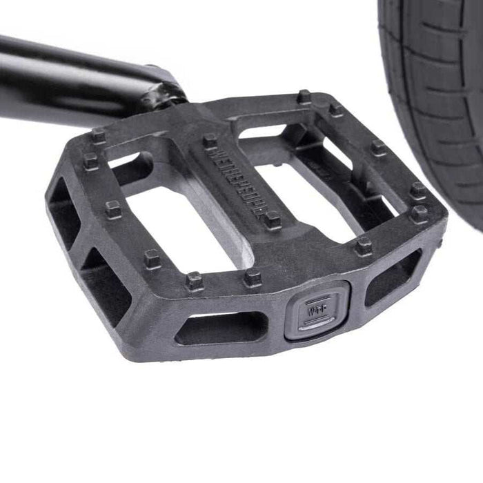 Close-up of Wethepeople Justice Bike black nylon fiberglass logic pedal near rear tire