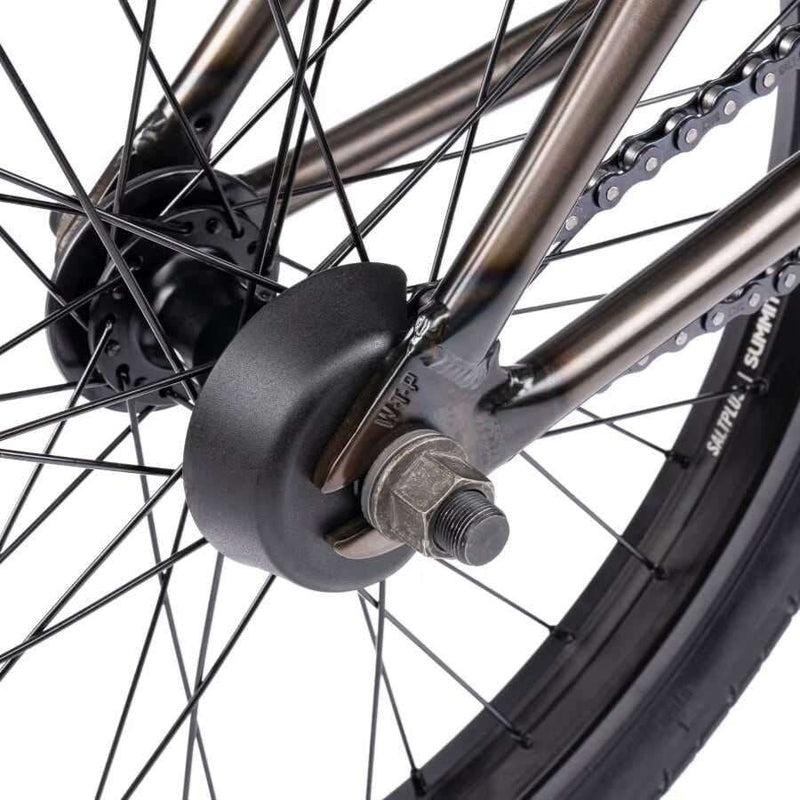 Close-up of the rear wheel hub and sprocket area on the Wethepeople Justice Complete BMX bike showing the hub guard, axle nut, spokes, and part of the chain on the saltplus summit rim with a black tire