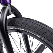 WETHEPEOPLE TRUST CS BMX bike close-up, showcasing "Activate" tire and "Trust" frame detailing.