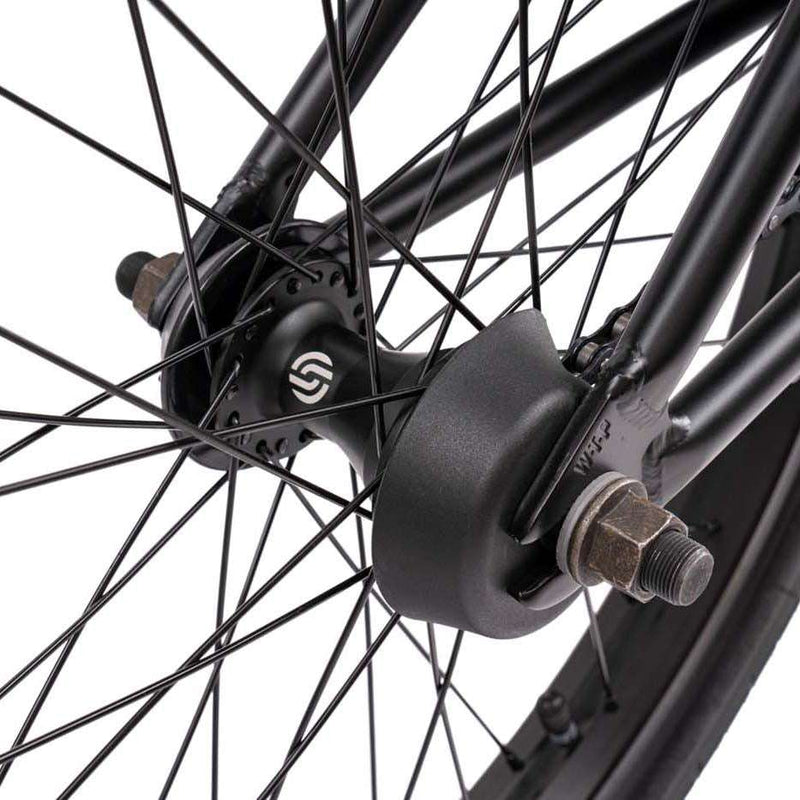 Close-up of Wethepeople Justice Bike rear wheel hub and plastic hub guard with black spokes and axle nuts