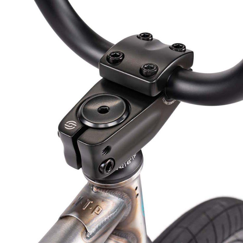 Close-up of black handlebar and stem on Wethepeople Justice bike with visible welds on the frame top tube