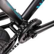 Close-up of the black Wethepeople Justice Bike drivetrain showing the chain, Paragon Plastic Guard sprocket, and part of the frame.