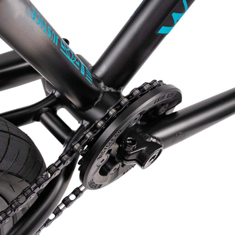 Close-up of the black Wethepeople Justice Bike drivetrain showing the chain, Paragon Plastic Guard sprocket, and part of the frame.