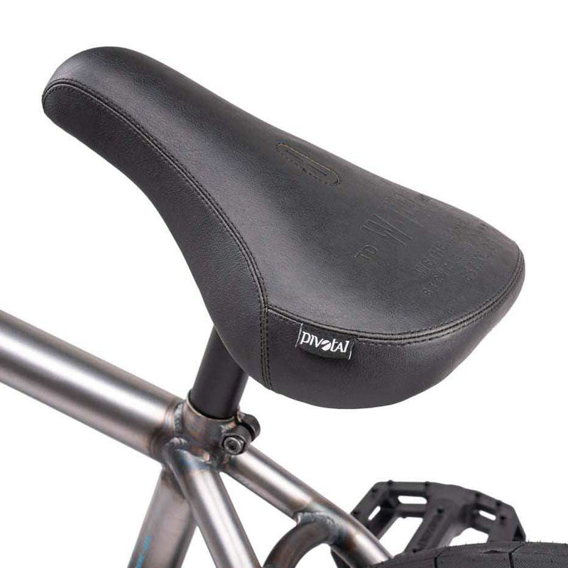 Close-up of the black pivotal saddle and gray frame tube of the Wethepeople Justice Complete BMX bike focusing on the seat and part of the pedal.