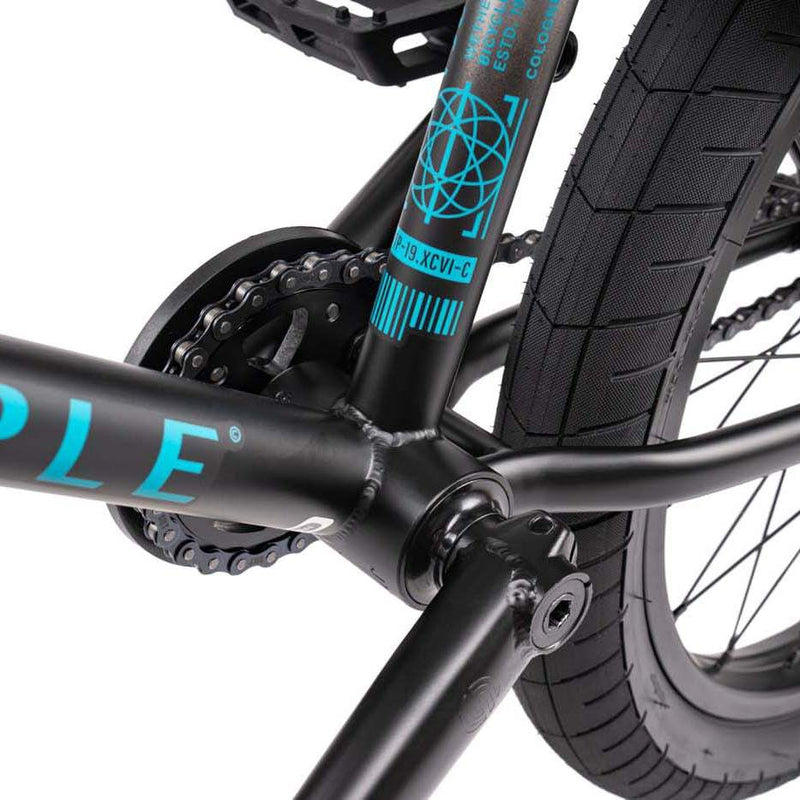 Close-up of black and turquoise WETHEPEOPLE JUSTICE BIKE bottom bracket, chainring, and rear tire.