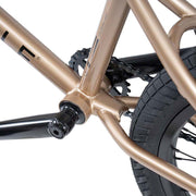 Close-up of the bottom bracket, chainstay, and rear tire of the WETHEPEOPLE CRYSIS COMPLETE BIKE with bronze frame and black components.